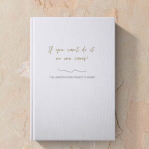 Mock up image of hardcover funny unmotivating project planner sitting on a desk. Light blue matte cover "If you can't do it, no one cares."