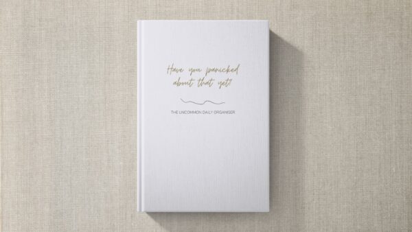 Mock up image of hardcover funny unmotivating project planner sitting on a desk. Light blue matte cover