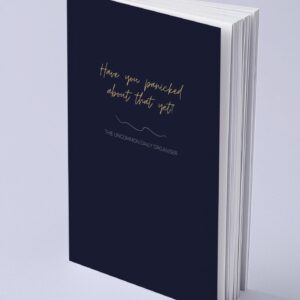 Mock up image of paperback funny unmotivating project planner sitting on a desk. Dark blue matte cover