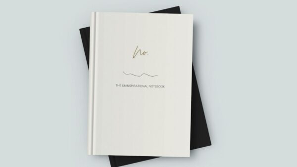 Mock up image of sleek hardcover notebook journal sitting on a desk. Ivory matte cover "No." Uninspirational notebook